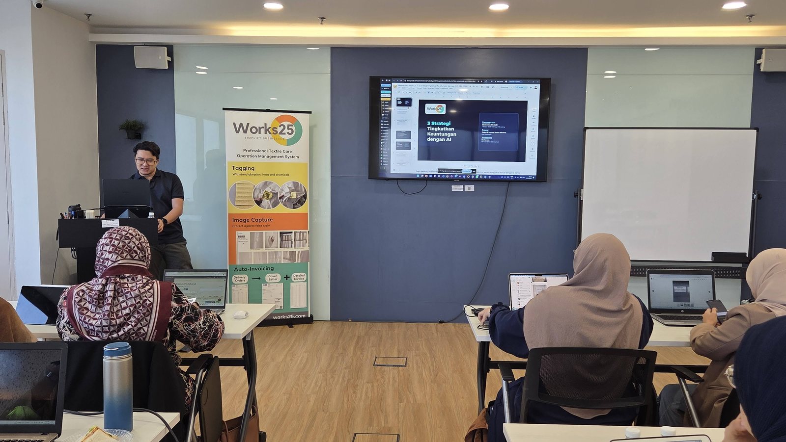 Peserta melihat paparan sistem Works25 pada skrin di hadapan