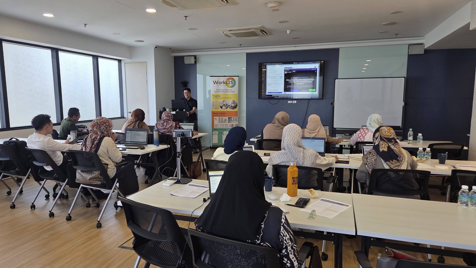 Peserta memberi tumpuan kepada paparan skrin di hadapan